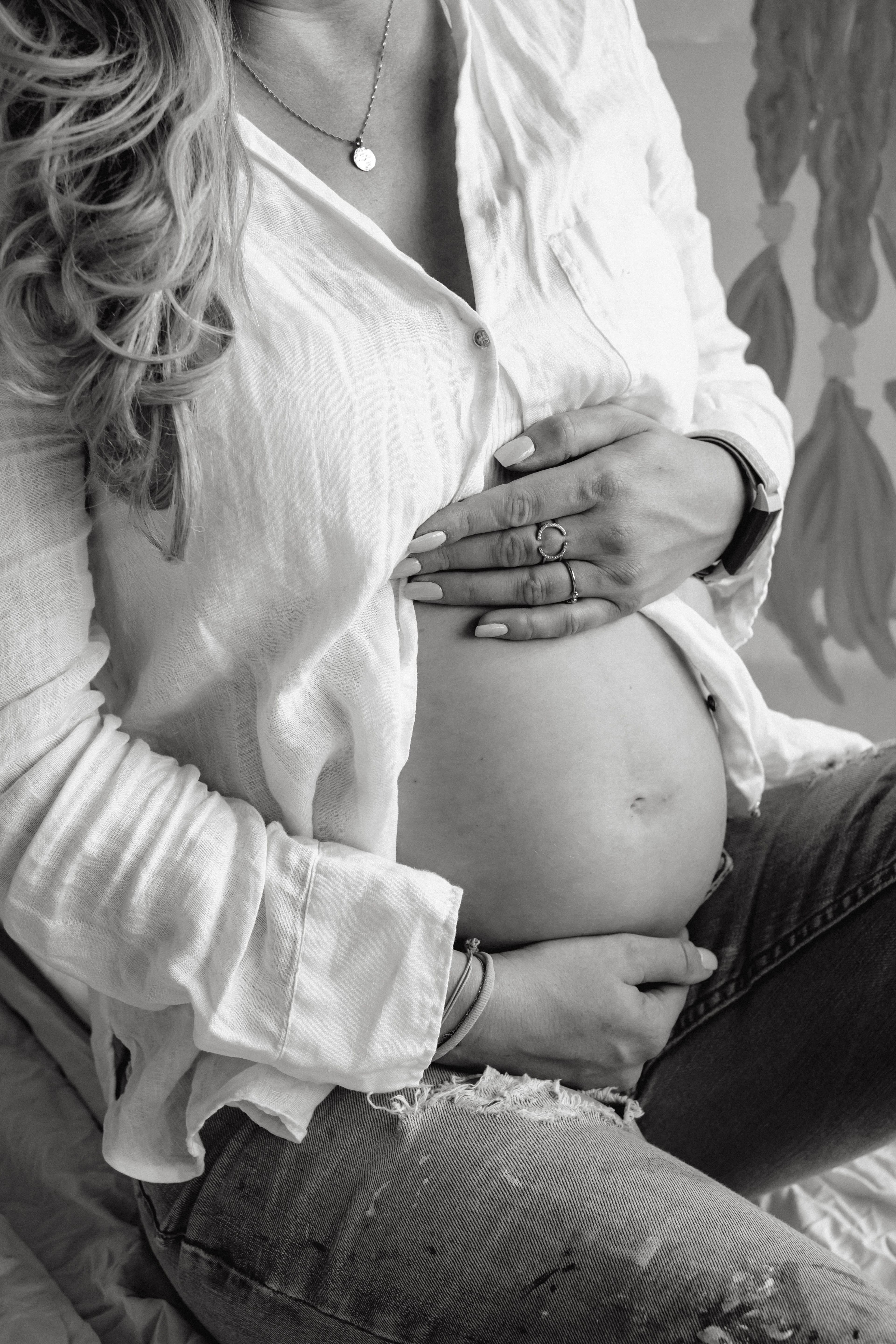 Mulher grávida segurando a barriga com as mãos