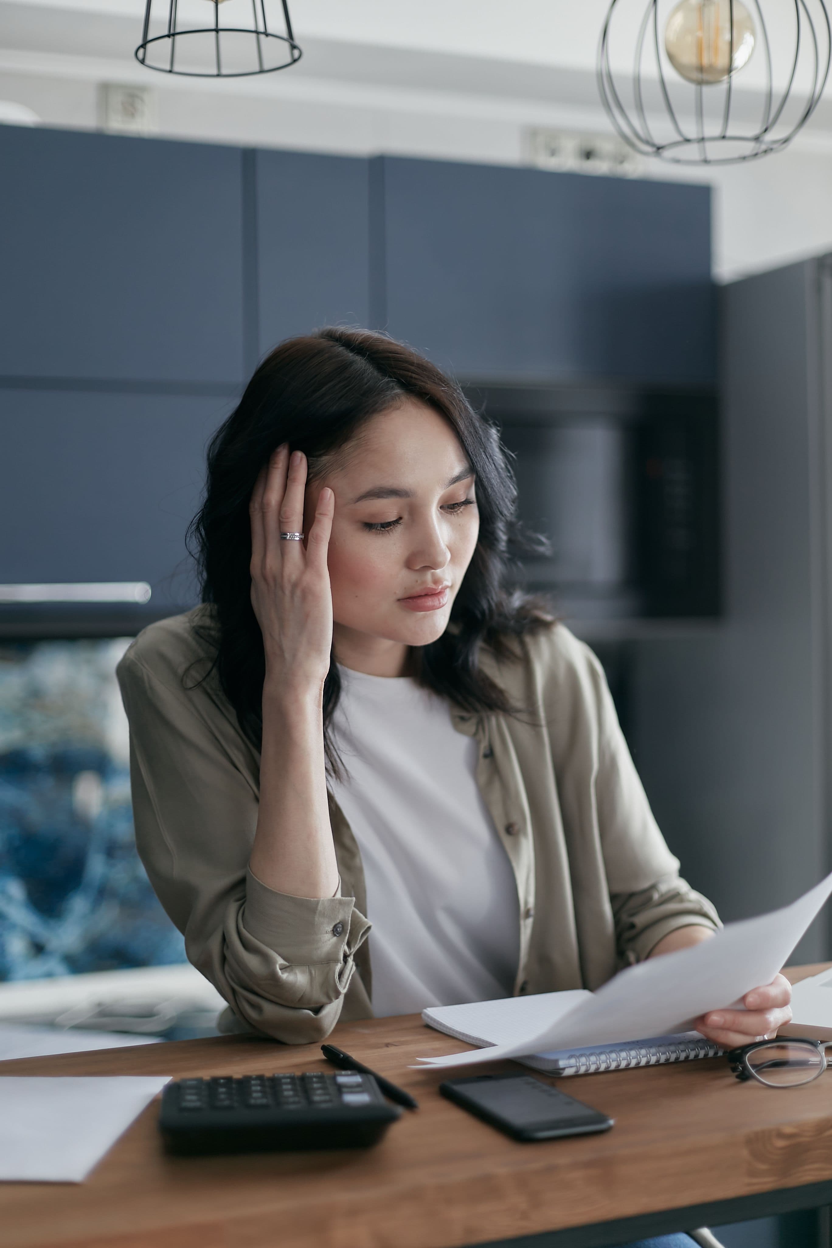 Mulher estressada com contas e documentos financeiros na mesa