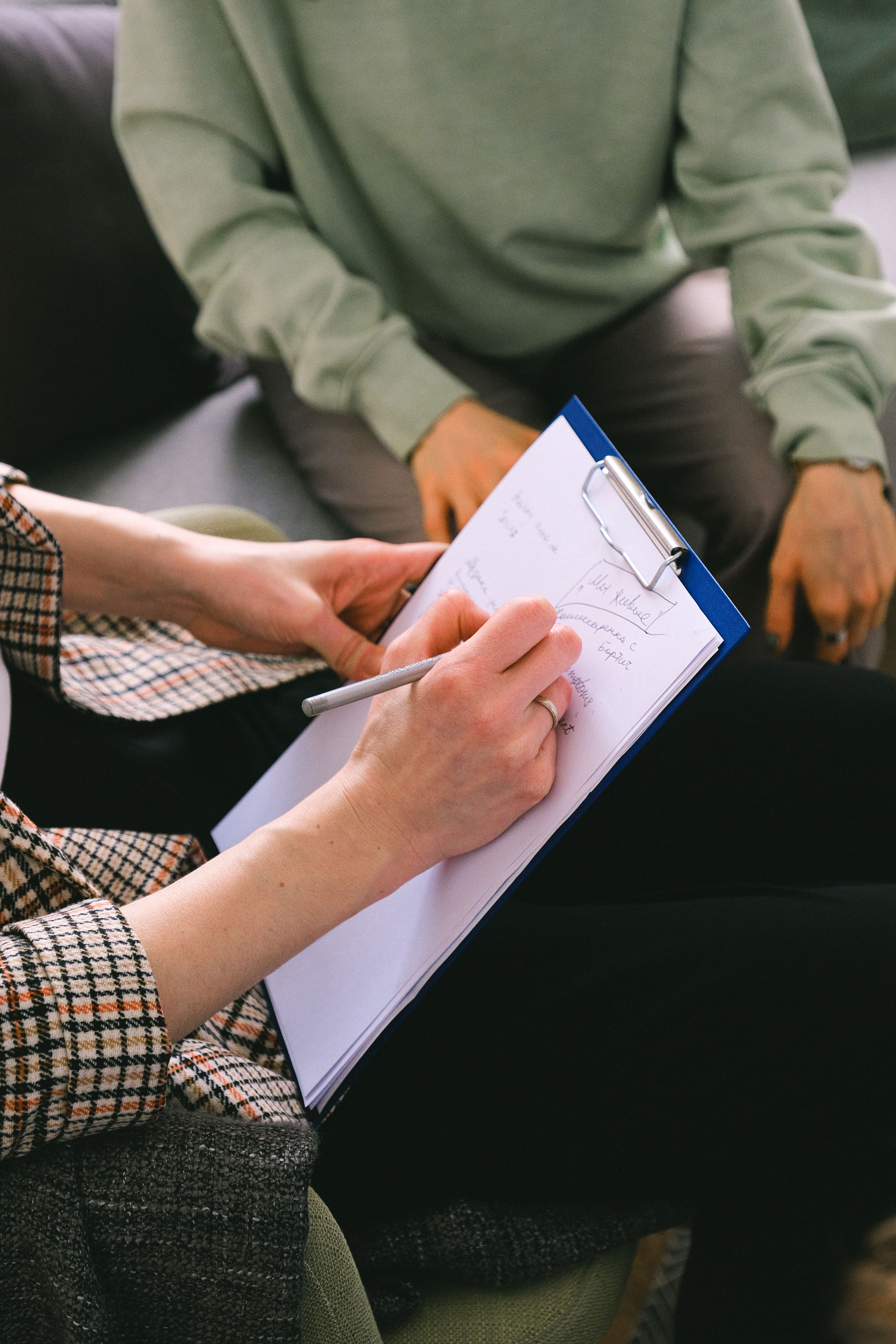 Profissional de saúde mental fazendo anotações durante consulta psiquiátrica