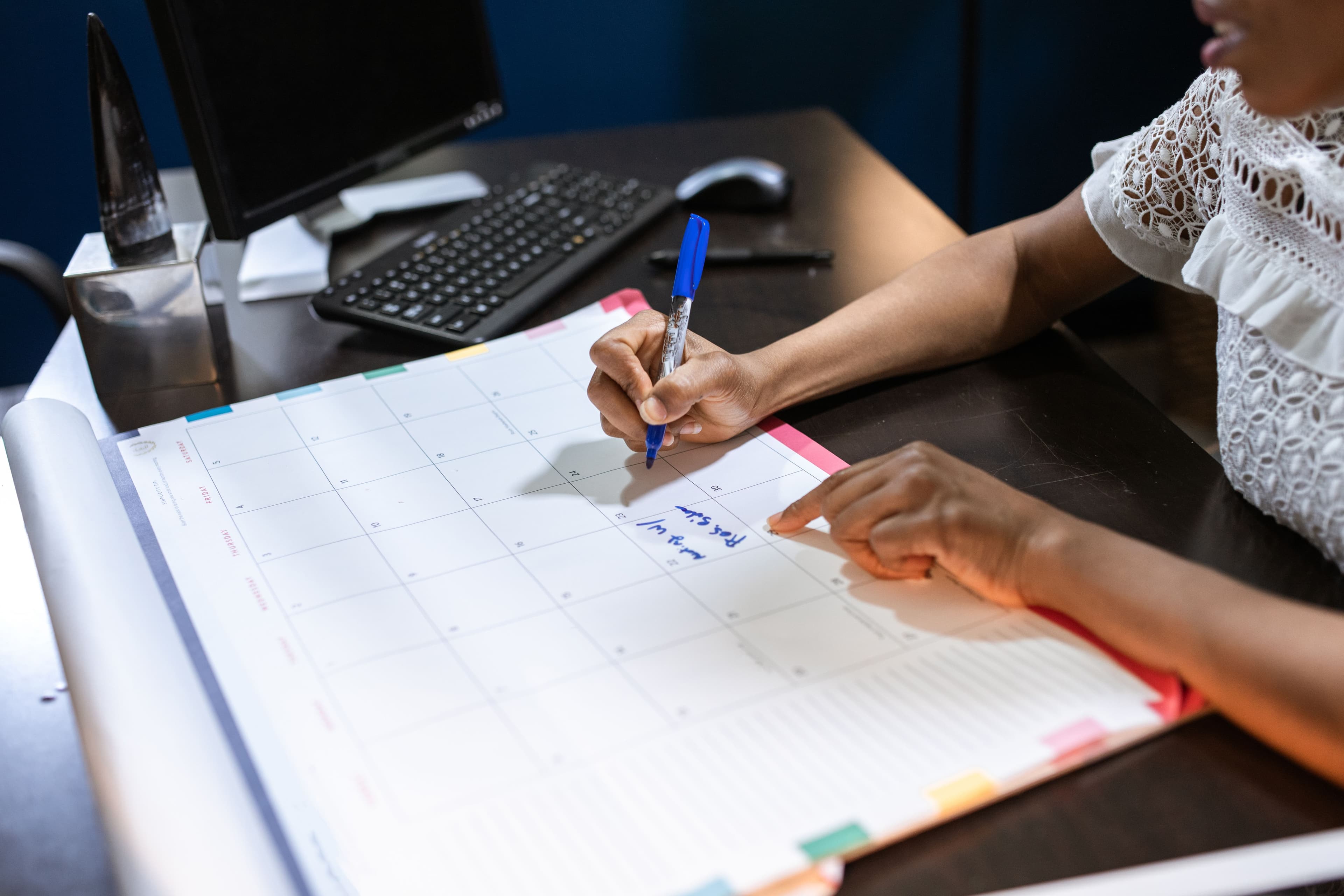 Mulher anotando datas em calendário mensal