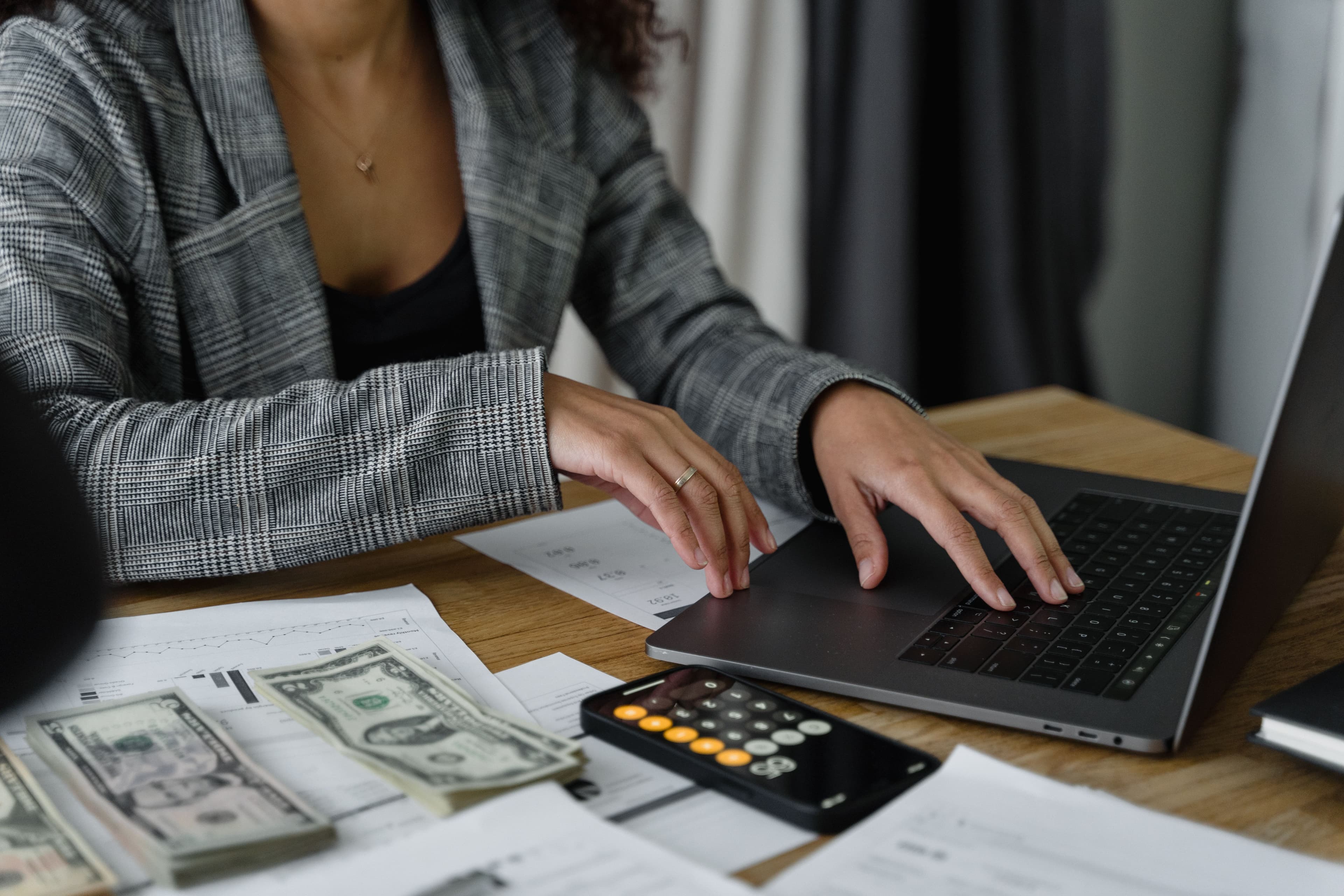 Pessoa calculando contas em papel com calculadora sobre mesa